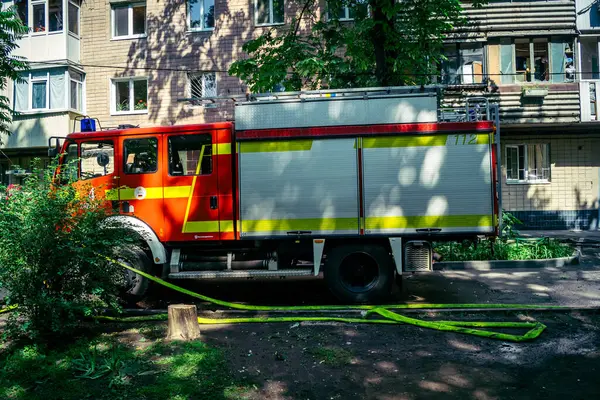 Kharkiv, Ukrayna, 7 Haziran 2025, Harkiv 'deki hasarlı binanın yakınına itfaiye araçları park edilmiştir. Hasar büyük, birkaç apartman yanıyor ve birçok pencere yıkıldı..