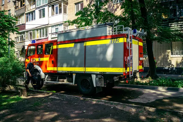 Kharkiv, Ukrayna, 7 Haziran 2025, Harkiv 'deki hasarlı binanın yakınına itfaiye araçları park edilmiştir. Hasar büyük, birkaç apartman yanıyor ve birçok pencere yıkıldı..