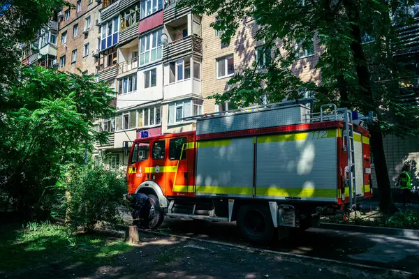 Kharkiv, Ukrayna, 7 Haziran 2025, Harkiv 'deki hasarlı binanın yakınına itfaiye araçları park edilmiştir. Hasar büyük, birkaç apartman yanıyor ve birçok pencere yıkıldı..