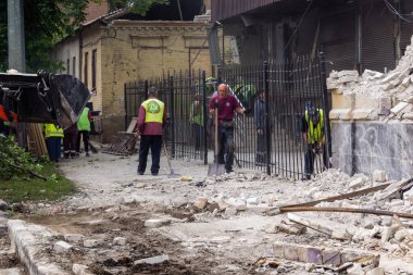 Kharkiv, Ukrayna, 12 Haziran 2025 Temizlikçiler bir Rus Shahed İHA 'sının çarptığı bir ev üzerinde çalışıyorlar. Hasar büyük, ev tamamen yıkılmış, yanmış ve çatısı sökülmüş..