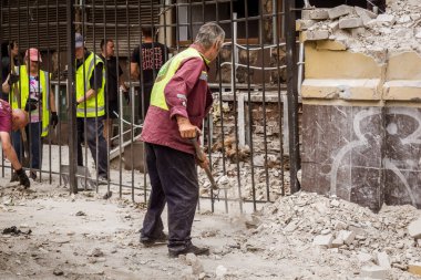 Kharkiv, Ukrayna, 12 Haziran 2025 Temizlikçiler bir Rus Shahed İHA 'sının çarptığı bir ev üzerinde çalışıyorlar. Hasar büyük, ev tamamen yıkılmış, yanmış ve çatısı sökülmüş..