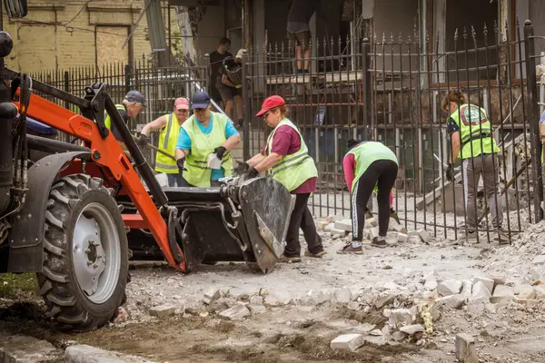 Kharkiv, Ukrayna, 12 Haziran 2025 Temizlikçiler bir Rus Shahed İHA 'sının çarptığı bir ev üzerinde çalışıyorlar. Hasar büyük, ev tamamen yıkılmış, yanmış ve çatısı sökülmüş..