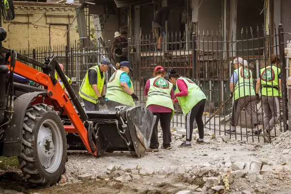 Kharkiv, Ukrayna, 12 Haziran 2025 Temizlikçiler bir Rus Shahed İHA 'sının çarptığı bir ev üzerinde çalışıyorlar. Hasar büyük, ev tamamen yıkılmış, yanmış ve çatısı sökülmüş..