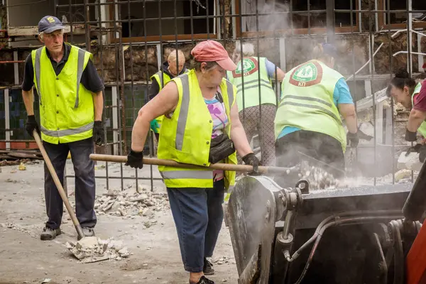 Kharkiv, Ukrayna, 12 Haziran 2025 Temizlikçiler bir Rus Shahed İHA 'sının çarptığı bir ev üzerinde çalışıyorlar. Hasar büyük, ev tamamen yıkılmış, yanmış ve çatısı sökülmüş..