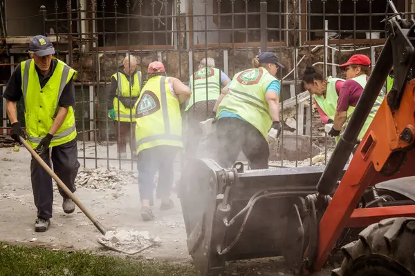 Kharkiv, Ukrayna, 12 Haziran 2025 Temizlikçiler bir Rus Shahed İHA 'sının çarptığı bir ev üzerinde çalışıyorlar. Hasar büyük, ev tamamen yıkılmış, yanmış ve çatısı sökülmüş..