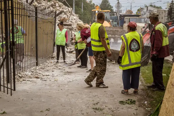 Kharkiv, Ukrayna, 12 Haziran 2025 Temizlikçiler bir Rus Shahed İHA 'sının çarptığı bir ev üzerinde çalışıyorlar. Hasar büyük, ev tamamen yıkılmış, yanmış ve çatısı sökülmüş..