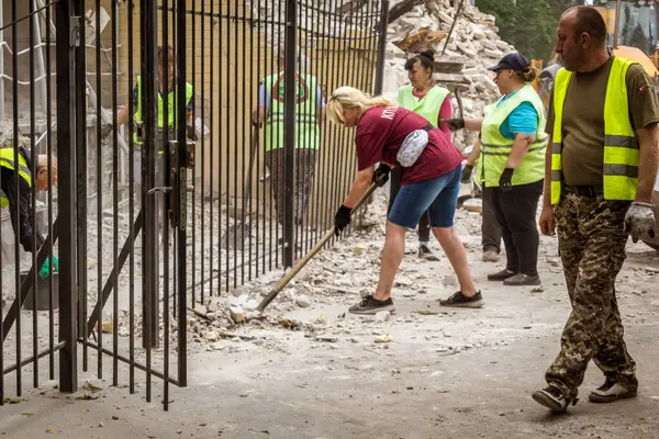 Kharkiv, Ukrayna, 12 Haziran 2025 Temizlikçiler bir Rus Shahed İHA 'sının çarptığı bir ev üzerinde çalışıyorlar. Hasar büyük, ev tamamen yıkılmış, yanmış ve çatısı sökülmüş..