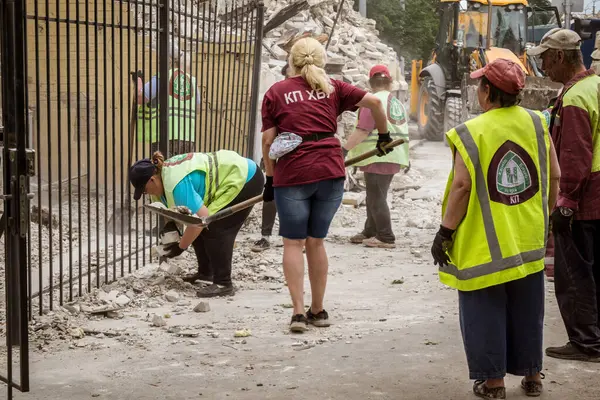Kharkiv, Ukrayna, 12 Haziran 2025 Temizlikçiler bir Rus Shahed İHA 'sının çarptığı bir ev üzerinde çalışıyorlar. Hasar büyük, ev tamamen yıkılmış, yanmış ve çatısı sökülmüş..