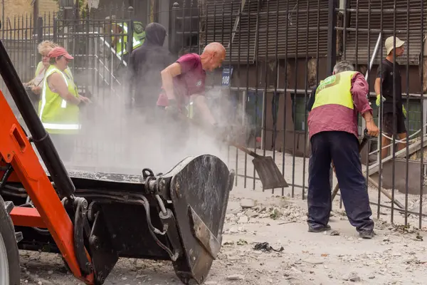 Kharkiv, Ukrayna, 12 Haziran 2025 Temizlikçiler bir Rus Shahed İHA 'sının çarptığı bir ev üzerinde çalışıyorlar. Hasar büyük, ev tamamen yıkılmış, yanmış ve çatısı sökülmüş..