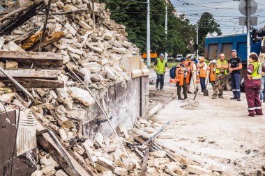 Kharkiv, Ukrayna, 12 Haziran 2025 Temizlikçiler bir Rus Shahed İHA 'sının çarptığı bir ev üzerinde çalışıyorlar. Hasar büyük, ev tamamen yıkılmış, yanmış ve çatısı sökülmüş..