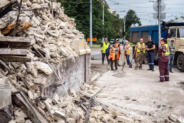 Kharkiv, Ukrayna, 12 Haziran 2025 Temizlikçiler bir Rus Shahed İHA 'sının çarptığı bir ev üzerinde çalışıyorlar. Hasar büyük, ev tamamen yıkılmış, yanmış ve çatısı sökülmüş..