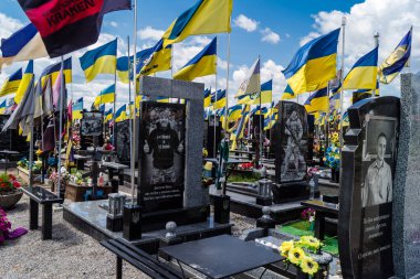 Kharkiv, Ukrayna, 3 Temmuz 2025 Ukrayna 'yı savunan kahramanların portresi. Sarı ve mavi bayraklar, Kharkiv' in güneyindeki bir askeri mezarlık olan Aleya Slavy 'ye kadar uzanıyor..