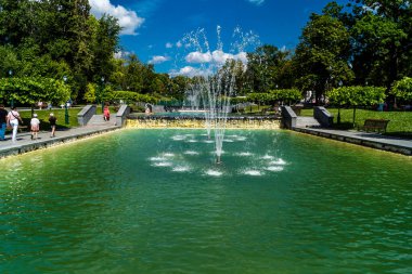 Kharkiv, Ukrayna, 4 Temmuz 2025 Shevchenko Bahçesi, yüzyıllık meşe ağaçları, fıskiyeler, çiçek yatakları ve spor malzemeleriyle Harkiv 'in göbeğindeki zarif park. İnsanlar oraya yürümeyi sever..