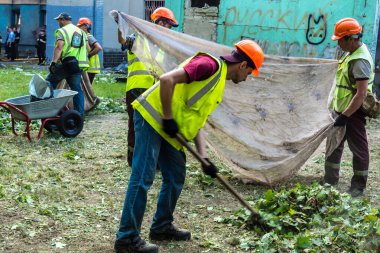 Kharkiv, Ukrayna, 7 Temmuz 2025 Temizlikçiler Kharkiv 'de bir Rus Şaban İHA' sının çarptığı bir bina üzerinde çalışıyorlar. Birçok apartmanın yanması ve pencerelerin tahrip olmasıyla hasar büyük oldu.