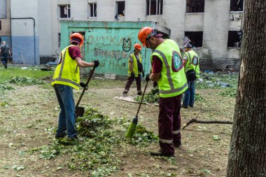 Kharkiv, Ukrayna, 7 Temmuz 2025 Temizlikçiler Kharkiv 'de bir Rus Şaban İHA' sının çarptığı bir bina üzerinde çalışıyorlar. Birçok apartmanın yanması ve pencerelerin tahrip olmasıyla hasar büyük oldu.
