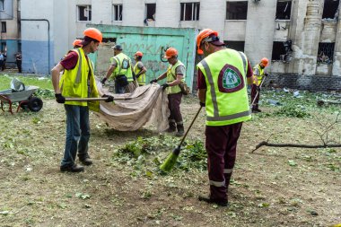 Kharkiv, Ukrayna, 7 Temmuz 2025 Temizlikçiler Kharkiv 'de bir Rus Şaban İHA' sının çarptığı bir bina üzerinde çalışıyorlar. Birçok apartmanın yanması ve pencerelerin tahrip olmasıyla hasar büyük oldu.
