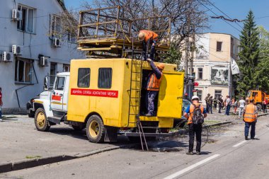 Kharkiv, Ukrayna, 7 Temmuz 2025 Rus Şaban İHA 'ları tarafından vurulan şehir merkezinde bakım servisleri çalışıyor. Yanan binalar ve yıkılan camlarla hasar büyük.