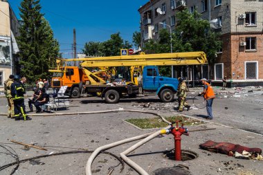 Kharkiv, Ukrayna, 7 Temmuz 2025 Rus Şaban İHA 'ları tarafından vurulan şehir merkezinde bakım servisleri çalışıyor. Yanan binalar ve yıkılan camlarla hasar büyük.
