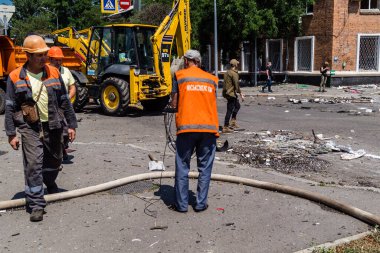 Kharkiv, Ukrayna, 7 Temmuz 2025. Temizlikçiler, Rus Shahed İHA 'larının çarptığı şehir merkezinde çalışıyorlar. Çok sayıda dükkan, bina yangını ve çok sayıda pencerenin tahrip olmasıyla hasar büyük.