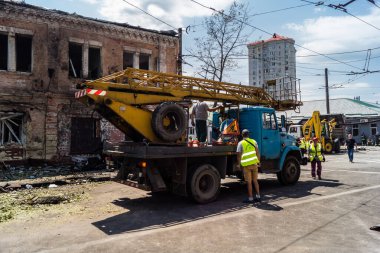 Kharkiv, Ukrayna, 7 Temmuz 2025 Rus Şaban İHA 'ları tarafından vurulan şehir merkezinde bakım servisleri çalışıyor. Yanan binalar ve yıkılan camlarla hasar büyük.