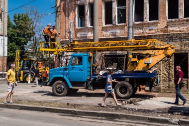 Kharkiv, Ukrayna, 7 Temmuz 2025 Rus Şaban İHA 'ları tarafından vurulan şehir merkezinde bakım servisleri çalışıyor. Yanan binalar ve yıkılan camlarla hasar büyük.