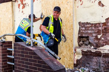 Kharkiv, Ukrayna, 7 Temmuz 2025 Rus Şaban İHA 'ları tarafından vurulan şehir merkezinde bakım servisleri çalışıyor. Yanan binalar ve yıkılan camlarla hasar büyük.