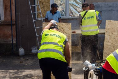 Kharkiv, Ukrayna, 7 Temmuz 2025 Rus Şaban İHA 'ları tarafından vurulan şehir merkezinde bakım servisleri çalışıyor. Yanan binalar ve yıkılan camlarla hasar büyük.