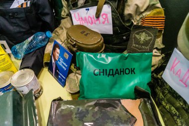 Kharkiv, Ukrayna, 22 Temmuz 2025. Savaş alanından çıkarılan belgeler ve mermiler gibi çeşitli Rus ordu eşyalarından oluşan askeri hatıralar. Bu eşyalar bir şeker dükkanında sergileniyor..