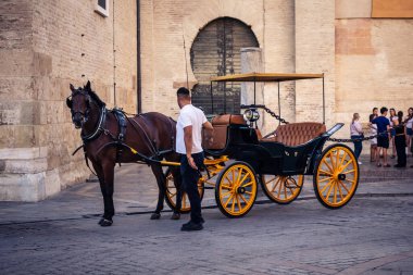 Seville, İspanya, 21 Eylül 2025. Atlı turistler Sevilla şehir merkezinin tarihi bölgesini ziyaret ediyor ve dar, pitoresk caddelerde yürüyor..
