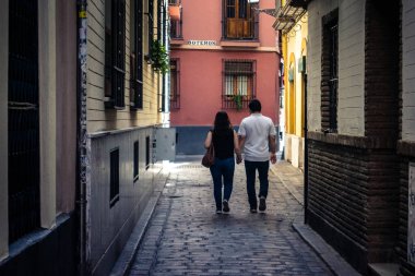 Seville, İspanya, 21 Eylül 2025 Sevilla şehir merkezinin tarihi bölgesini ziyaret eden turistler dar, pitoresk caddelerde yürüyorlar..