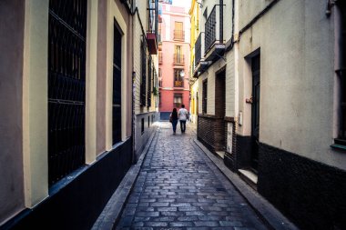Seville, İspanya, 21 Eylül 2025 Sevilla şehir merkezinin tarihi bölgesini ziyaret eden turistler dar, pitoresk caddelerde yürüyorlar..