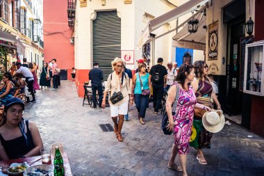Seville, İspanya, 21 Eylül 2025 Sevilla şehir merkezinin tarihi bölgesini ziyaret eden turistler dar, pitoresk caddelerde yürüyorlar..