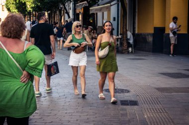 Seville, İspanya, 21 Eylül 2025 Sevilla şehir merkezinin tarihi bölgesini ziyaret eden turistler dar, pitoresk caddelerde yürüyorlar..