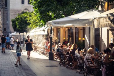 Seville, İspanya, 21 Eylül 2025 Sevilla şehir merkezinin tarihi bölgesini ziyaret eden turistler dar, pitoresk caddelerde yürüyorlar..