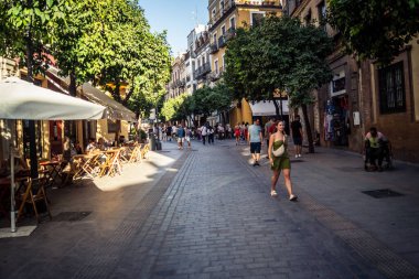 Seville, İspanya, 21 Eylül 2025 Sevilla şehir merkezinin tarihi bölgesini ziyaret eden turistler dar, pitoresk caddelerde yürüyorlar..