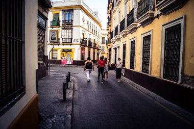 Seville, İspanya, 21 Eylül 2025 Sevilla şehir merkezinin tarihi bölgesini ziyaret eden turistler dar, pitoresk caddelerde yürüyorlar..