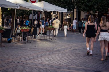 Seville, İspanya, 21 Eylül 2025 Sevilla şehir merkezinin tarihi bölgesini ziyaret eden turistler dar, pitoresk caddelerde yürüyorlar..
