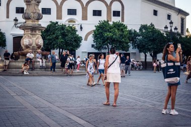 Seville, İspanya, 21 Eylül 2025 Sevilla şehir merkezinin tarihi bölgesini ziyaret eden turistler dar, pitoresk caddelerde yürüyorlar..