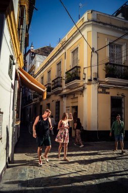 Seville, İspanya, 21 Eylül 2025 Sevilla şehir merkezinin tarihi bölgesini ziyaret eden turistler dar, pitoresk caddelerde yürüyorlar..