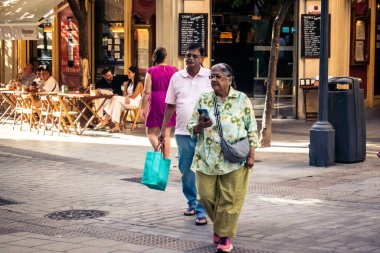 Seville, İspanya, 21 Eylül 2025 Sevilla şehir merkezinin tarihi bölgesini ziyaret eden turistler dar, pitoresk caddelerde yürüyorlar..