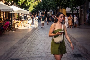 Seville, İspanya, 21 Eylül 2025 Sevilla şehir merkezinin tarihi bölgesini ziyaret eden turistler dar, pitoresk caddelerde yürüyorlar..