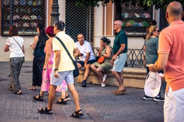Seville, İspanya, 21 Eylül 2025 Sevilla şehir merkezinin tarihi bölgesini ziyaret eden turistler dar, pitoresk caddelerde yürüyorlar..
