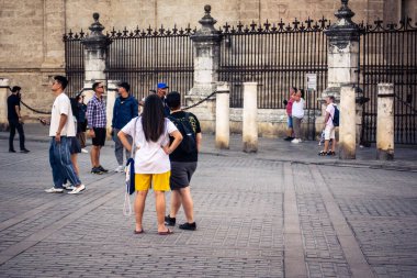 Seville, İspanya, 21 Eylül 2025 Sevilla şehir merkezinin tarihi bölgesini ziyaret eden turistler dar, pitoresk caddelerde yürüyorlar..