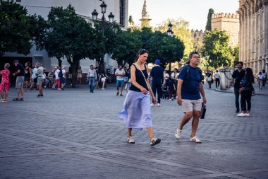 Seville, İspanya, 21 Eylül 2025 Sevilla şehir merkezinin tarihi bölgesini ziyaret eden turistler dar, pitoresk caddelerde yürüyorlar..