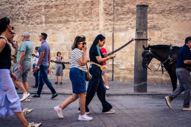 Seville, İspanya, 21 Eylül 2025 Sevilla şehir merkezinin tarihi bölgesini ziyaret eden turistler dar, pitoresk caddelerde yürüyorlar..