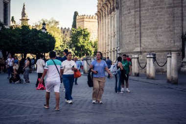 Seville, İspanya, 21 Eylül 2025 Sevilla şehir merkezinin tarihi bölgesini ziyaret eden turistler dar, pitoresk caddelerde yürüyorlar..