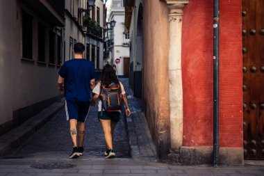 Seville, İspanya, 21 Eylül 2025 Sevilla şehir merkezinin tarihi bölgesini ziyaret eden turistler dar, pitoresk caddelerde yürüyorlar..