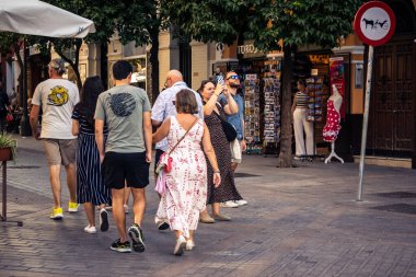 Seville, İspanya, 21 Eylül 2025 Sevilla şehir merkezinin tarihi bölgesini ziyaret eden turistler dar, pitoresk caddelerde yürüyorlar..