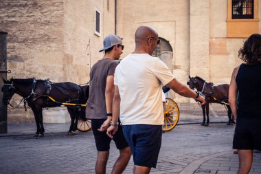 Seville, İspanya, 21 Eylül 2025 Sevilla şehir merkezinin tarihi bölgesini ziyaret eden turistler dar, pitoresk caddelerde yürüyorlar..
