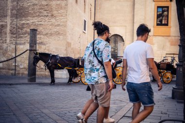Seville, İspanya, 21 Eylül 2025 Sevilla şehir merkezinin tarihi bölgesini ziyaret eden turistler dar, pitoresk caddelerde yürüyorlar..
